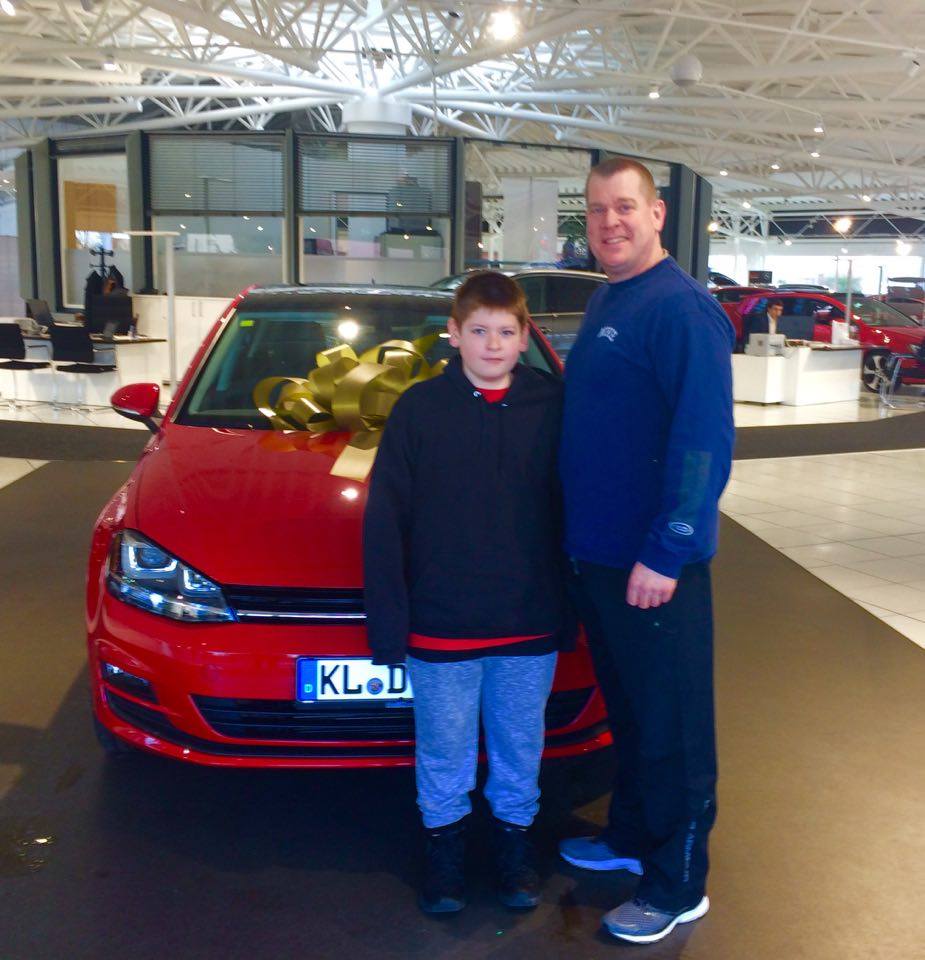 Kenneth M. and his son next to their brand-new Volkswagen 